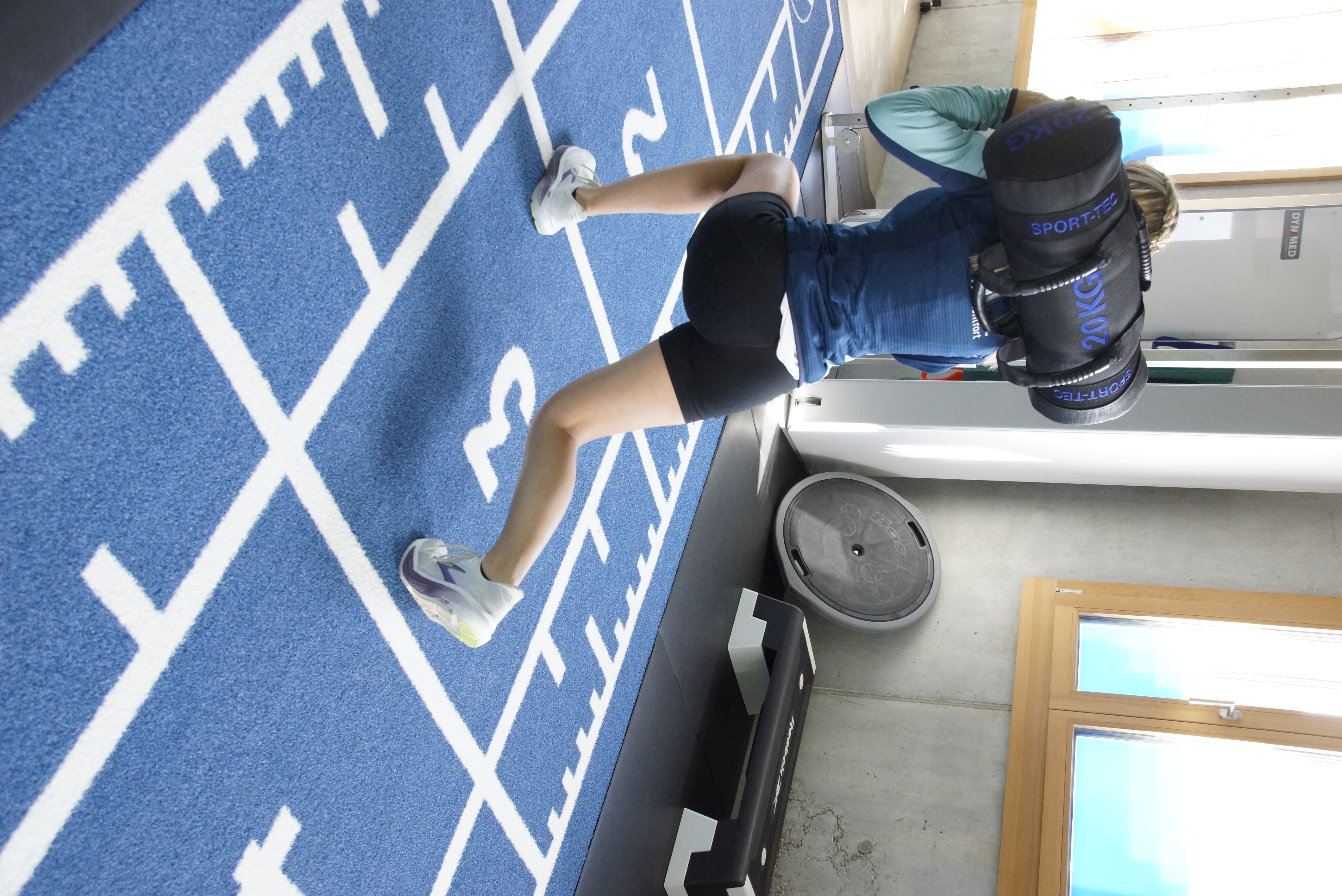 Sportphysiotherapeutisches Training mit Gewichten auf dem Kunstrasen
