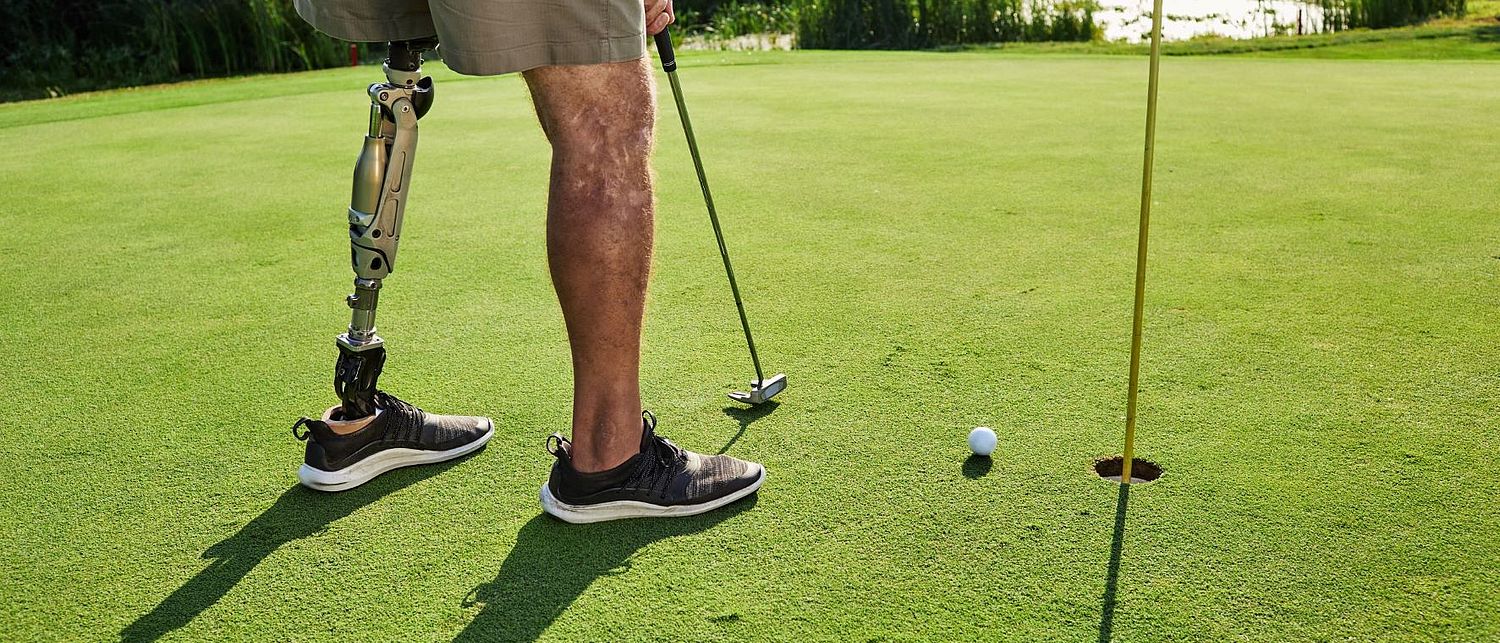 Person mit Beinprothese beim Golfspielen